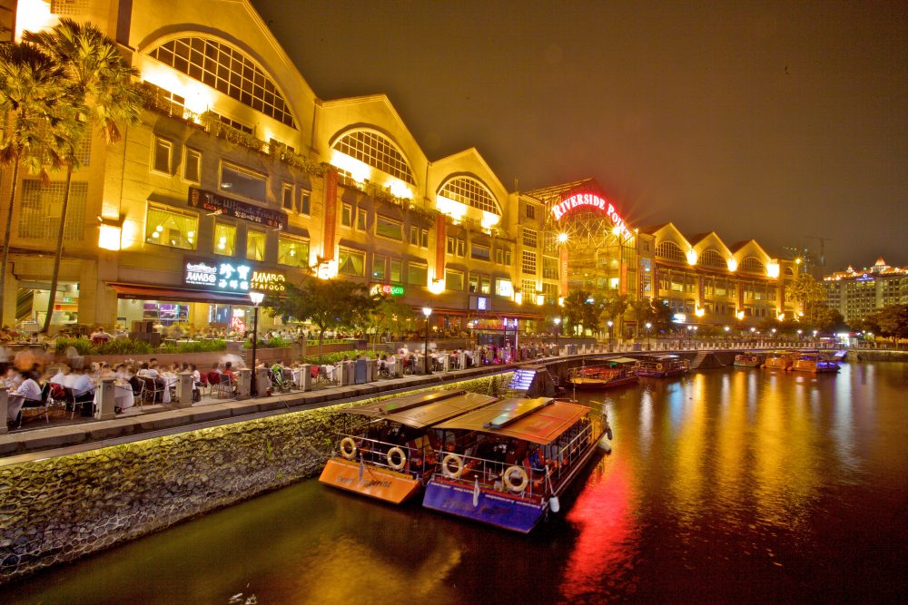Nighttime view of restaurants lining the water at Clarke Quay Mall